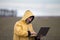 Farmer with laptop in field on cold day