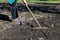 the farmer loosens the soil with a rake in the garden