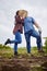 Farmer, love and couple kiss hiding with a hat on agriculture, sustainability and green farm showing new growth on soil