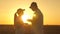 Farmer man and woman work with a tablet in wheat field in sun. silhouette of agronomist and businessman with tablet