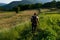 Farmer Mowing Grass around Vegetable Garden at Sunset on Warm Summer Day - Serene Rural Landscape