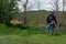 Farmer mowing grass with hand lawn gasoline mower on spring day