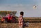 Farmer navigating drone above farmland