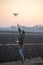 Farmer navigating drone above farmland