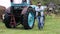 Farmer near an old worn-out tractor with rust. The crisis in agribusiness