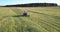 Farmer operates mower emitting smoke in atmosphere