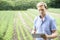 Farmer On Organic Farm Using Digital Tablet