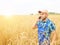 Farmer in a plaid shirt controlled his field. Talking on the phone. Wheat harvest.