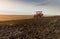 Farmer plowing stubble field