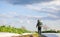 A farmer with a poison sprayer walks across the plantation field. Protection of cultivated plants from insects and fungal