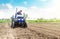 Farmer is processing soil on a tractor. Soil milling, crumbling mixing. Loosening surface, cultivating land for further planting.