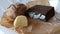 Farmer is putting loaves of rye and wheat bread, cheese and meat on the table. Preparation of little snack