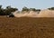 Farmer raises clouds of dust as he ploughs his dry