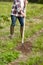 Farmer with rearer weeding garden bed at farm