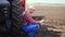 Farmer, in red plaid shirt, is typing to tablet smth, sitting near the big wheel of the tractor. agricultural machinery