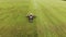 Farmer on a red tractor with a combined mounted mower with disc rotary knives mows grass into silage for livestock feed