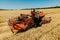 farmer rides an old combine to work. Combine harvester goes on way to harvest wheat.