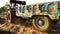 Farmer riding the tractor for unloading the trolley full of fertilizer outdoor in the field located in rural India