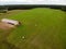 Farmer's grren field with hay rolls. farm building countryside Aerial drone view