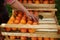 The farmer`s hands stacks fresh persimmon fruit in wooden box