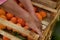 The farmer`s hands stacks fresh persimmon fruit in wooden box