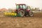 Farmer seeding, sowing crops at field.