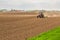 Farmer seeding, sowing crops at field.