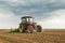 Farmer seeding, sowing crops at field.