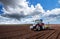 Farmer seeding, sowing crops at field.