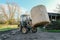 Farmer seen transporting a large bale of hay on a dairy farm.