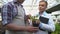 Farmer showing plant to quality control official, organic food production