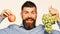 Farmer shows harvest. Winegrower with excited face holds grapes