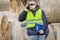 Farmer with smartphone and folder near the hay bales