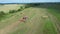 The farmer speeds up the drying of the hay by moving the harvested hay with the help of a tractor tedder. Top wiev.