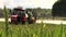 Farmer spray agricultural tractor fertilizer on cereal field