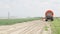 Farmer spraying water over a field with onions