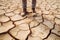 Farmer standing on parched landscape. Drought, disaster and crop failure.