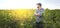 A farmer stands against the background of an agricultural field of sunflowers, selective focus, panorama