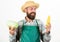Farmer straw hat hold corncob cabbage vegetable. Man bearded presenting corncob maize and cabbage white background