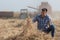 Farmer with tablet in front of combine harvester in soybean field