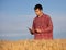Farmer with tablet in golden wheat field