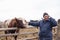 The farmer is talking on the phone and stroking the bull. Businessman in the village.