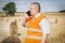 Farmer talking on smartphone near hay bales