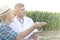 Farmer talking to scientist with digital tablet at farm