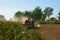 A farmer tilling soil for seedbed preparation with a Rotavator â€˜Rotary tillerâ€™ machine