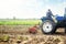 Farmer on a tractor cultivates a farm field. Soil milling, crumbling and mixing. Grinding and loosening soil, removing plants and