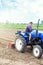 A farmer on a tractor cultivates a farm field. Soil milling, crumbling and mixing. Loosening the surface, cultivating the land for