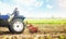 Farmer on a tractor cultivates a farm field. Work on preparing the soil for a new sowing of seeds of agricultural crops. Soil