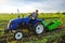 A farmer on a tractor digs potatoes with a digger. The use of modern technology on the farm. Free people from heavy land work