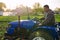 A farmer on a tractor drives across the farm field. Agro industry, agribusiness. Potato harvest campaign. Farming, agriculture.